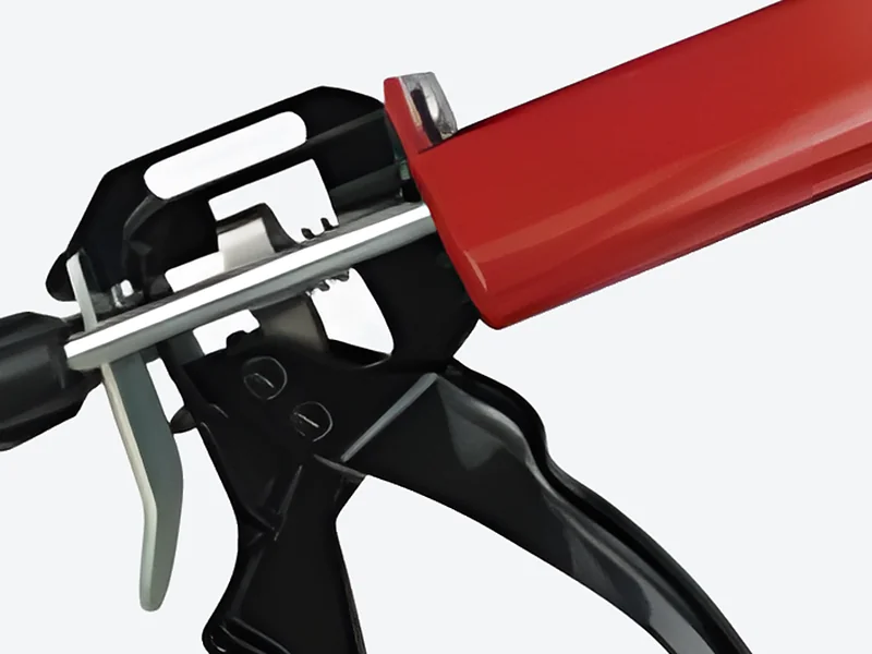 Show a close-up: Close-up of the trigger, ratchet plunger rods and red cartridge frame of the manual applicator