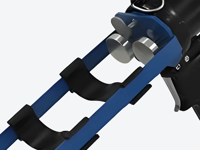 Show a close-up: Close-up of the blue open cartridge frame, twin plungers and black pistol grip of the pneumatic applicator
