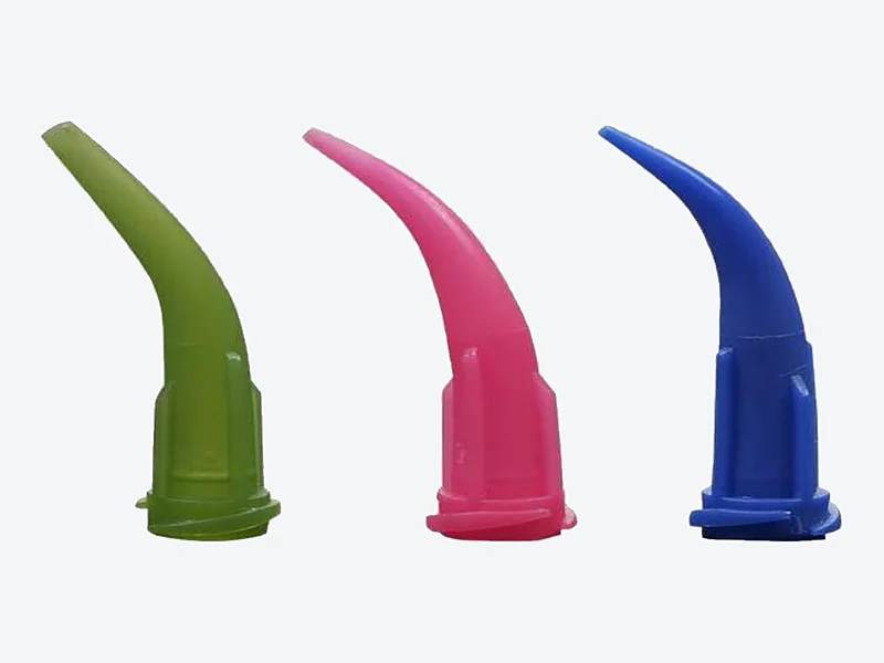 Three curved plastic dispensing tips in green, pink and blue