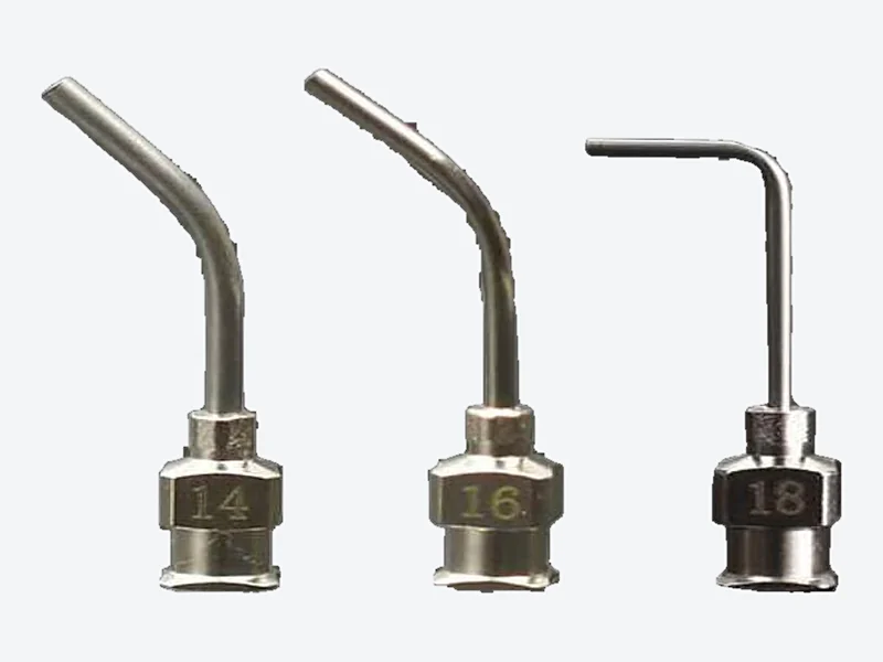 Four all-metal dispensing needles with bent tubes, one at a right angle, with the gauge number stamped on each hub