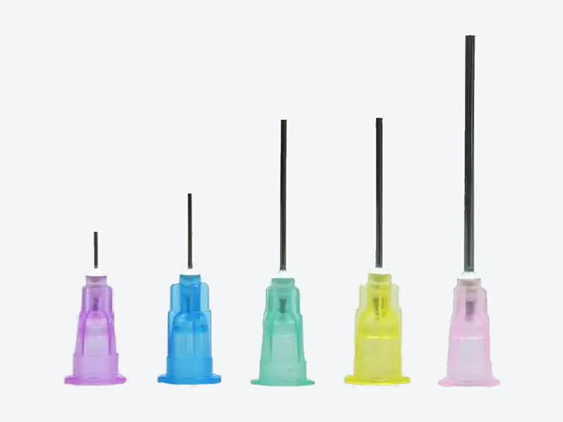 Five dispensing needles with lilac, blue, teal, yellow and pink plastic hubs and stainless steel tubes in short to long lengths