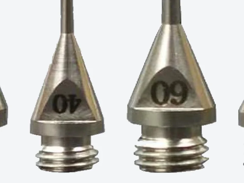 Show a close-up: Close-up of two conical metal machine dispensing tips with engraved size numbers and threaded bases